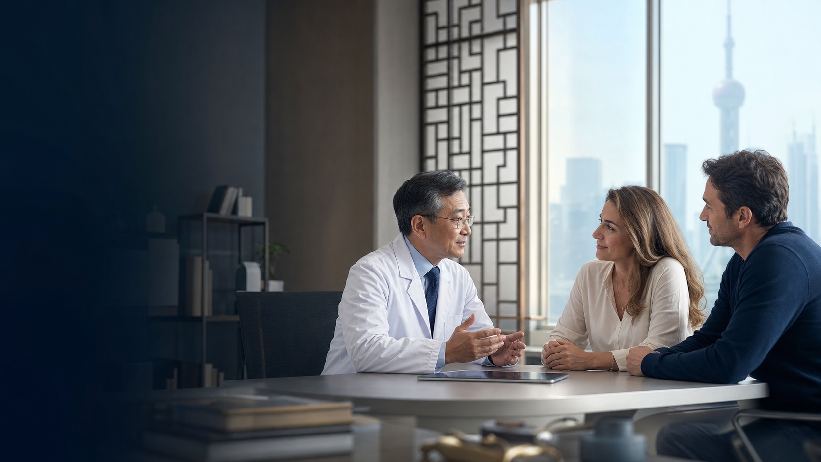 Chinese oncologist speaking with an international patient and her partner in a modern Shanghai consultation room